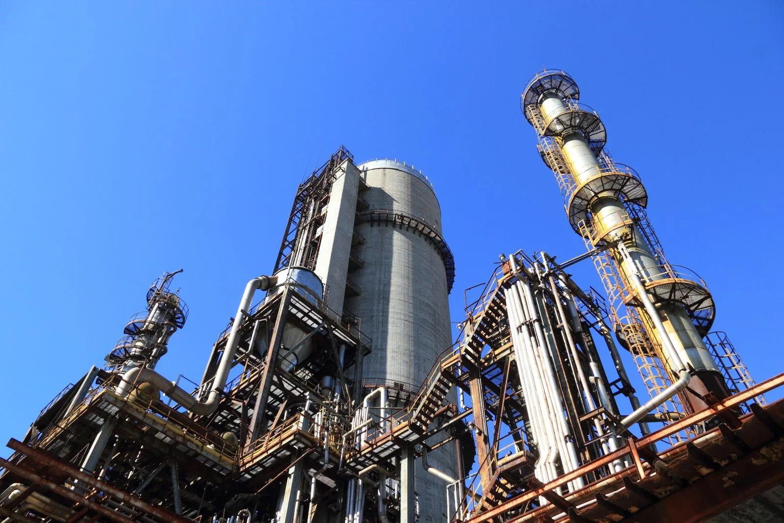 Oil refinery towers under blue sky as Brent crude climbs after Trump denies Iran sanctions relief