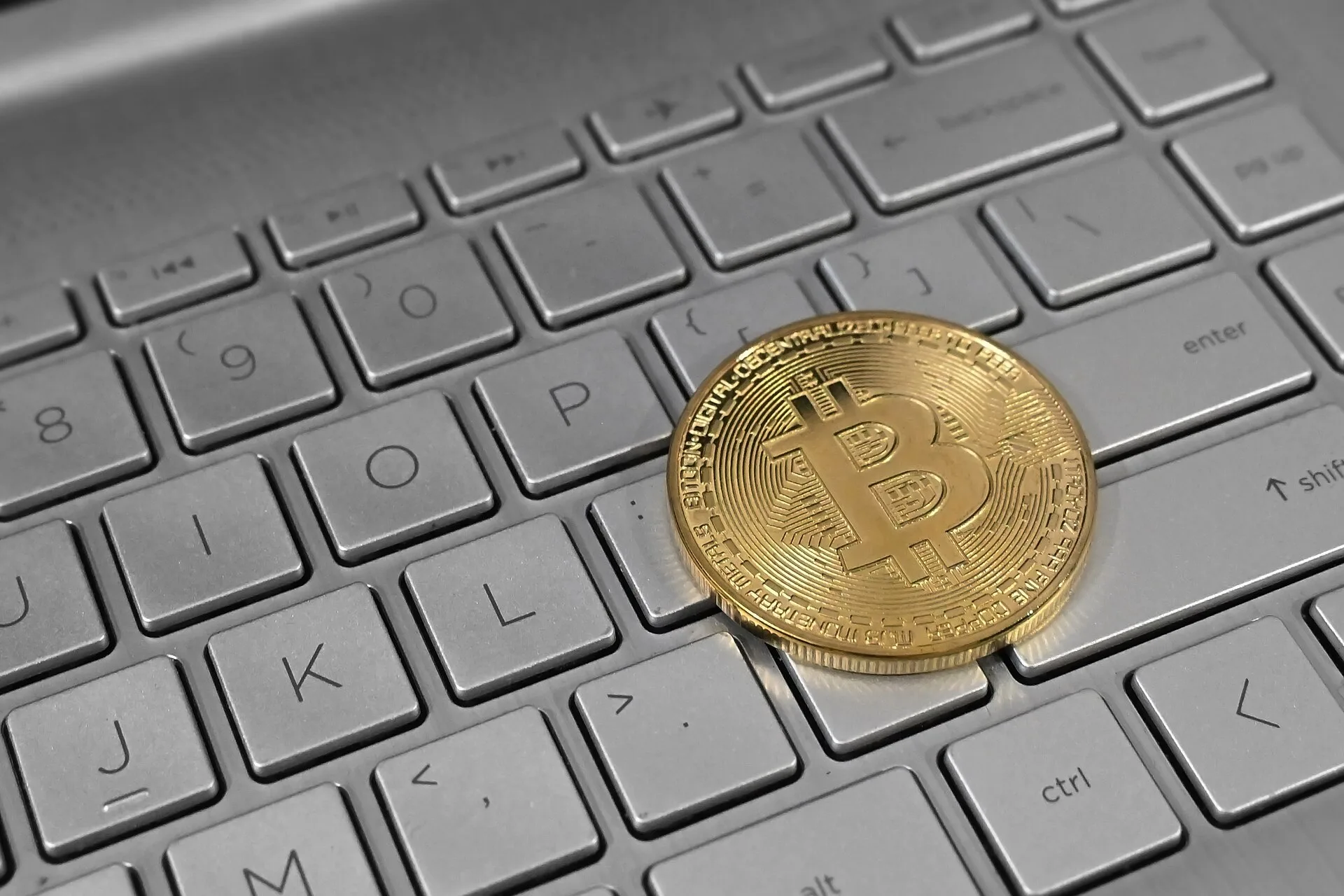 Physical bitcoin coin on laptop keyboard as Arthur Hayes predicts 1 million bitcoin by 2030