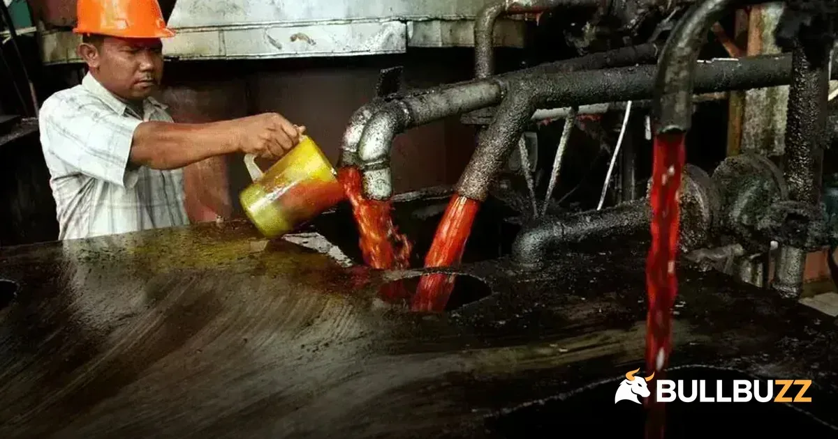 Malaysia palm oil stocks preview: worker samples oil flowing from processing machinery