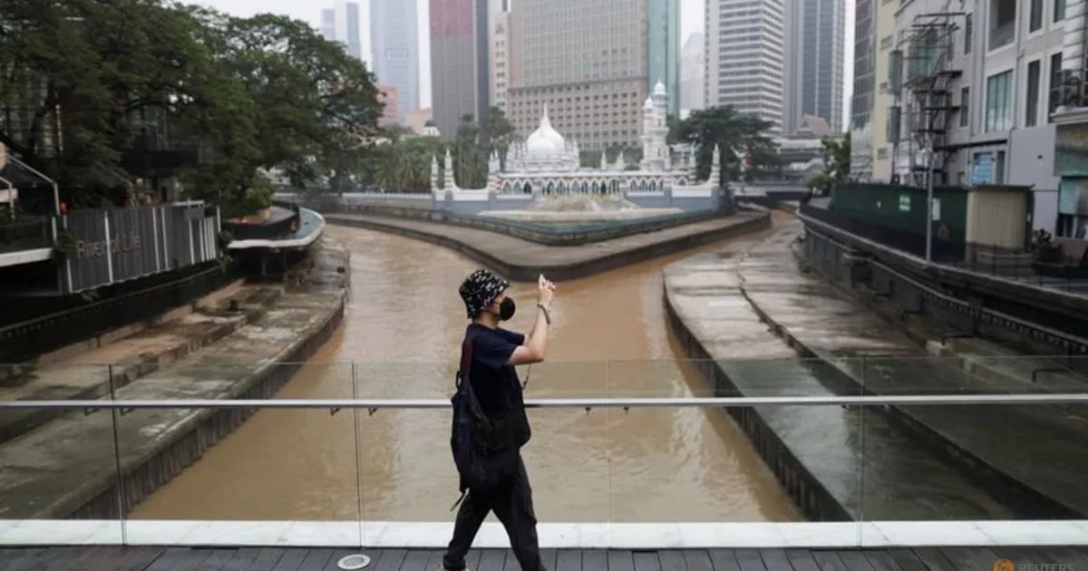 Malaysia economy grows 5.3% as a pedestrian photographs central Kuala Lumpur